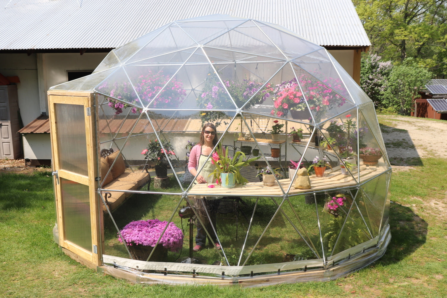 Outside photo of a 16 ft greenhouse with a clear vinyl cover.