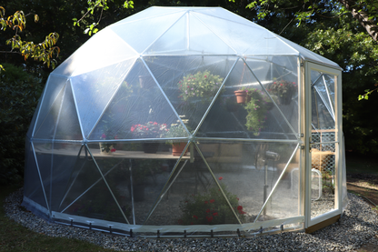 Outside photo of a 20 ft greenhouse with a reinforced clear vinyl cover and a storm door.